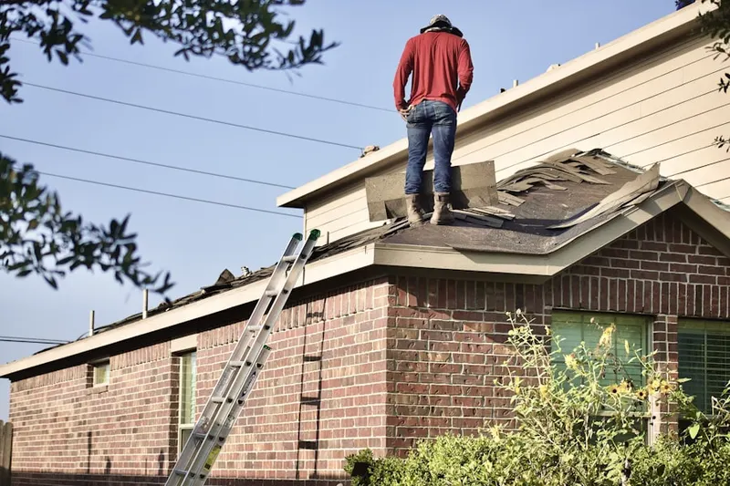 Professional roofer working on a residential roof in Marinette